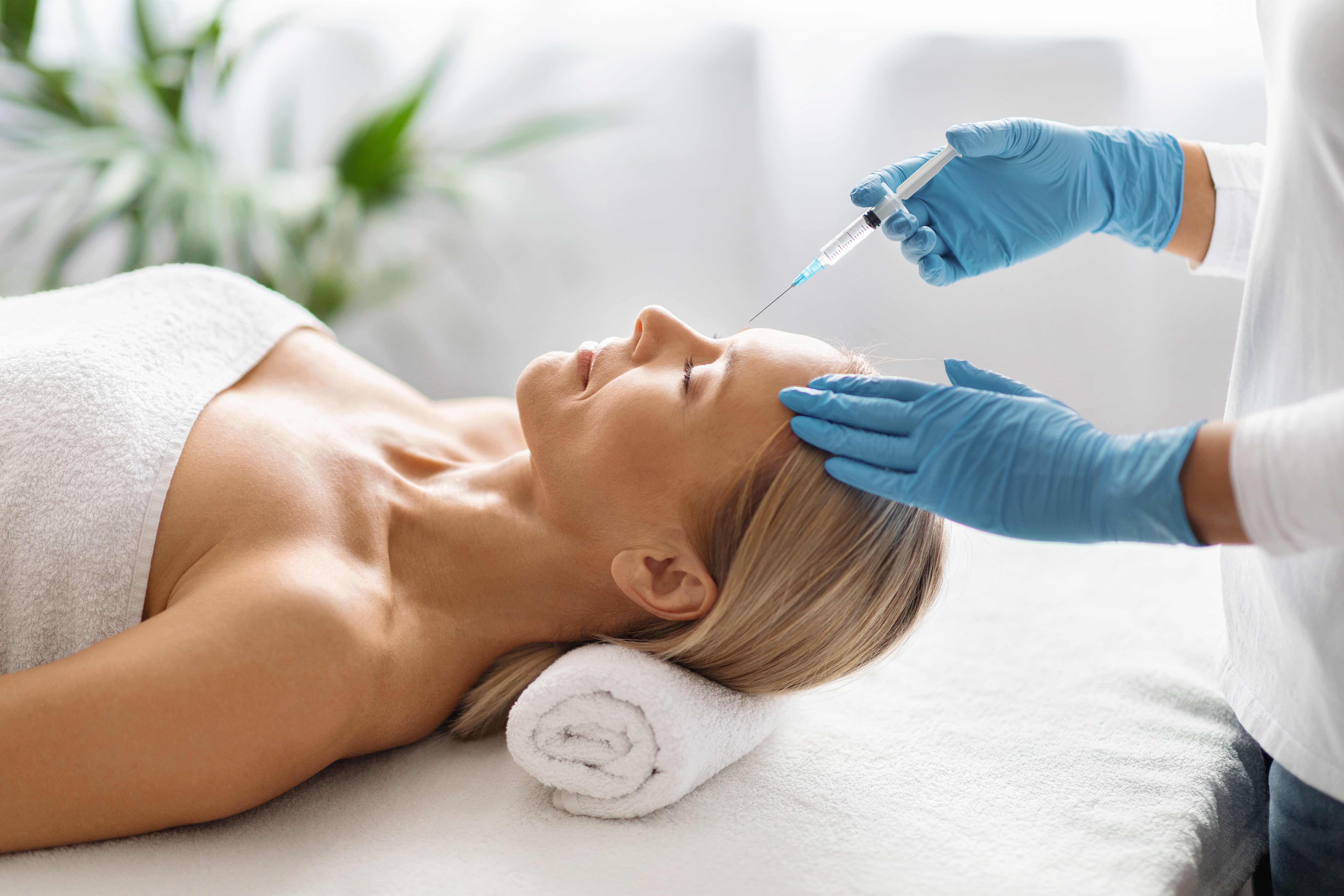 Beautiful mature woman getting an interbrow injection for aesthetic purposes at spa